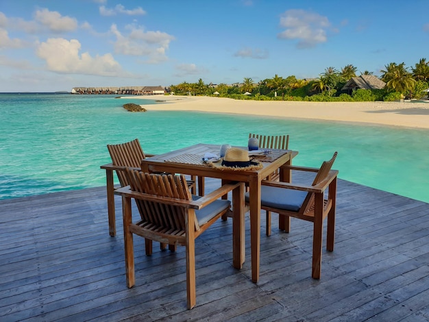 Tavolo e sedie in legno sullo sfondo del mare