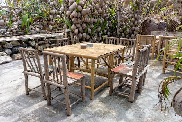 Wooden table and chairs in empty beach cafe next to sea Island Koh Phangan Thailand