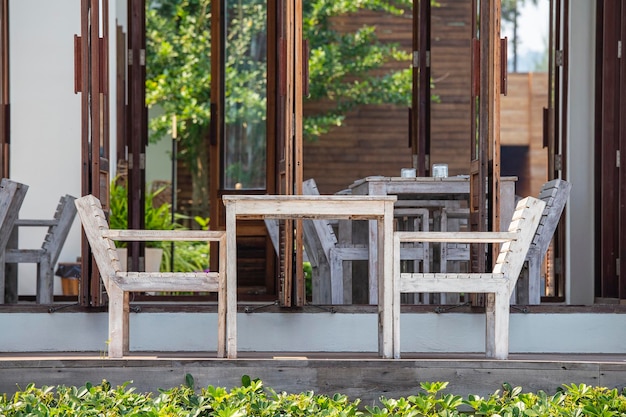 Wooden table and chairs in empty beach cafe next to sea Thailand