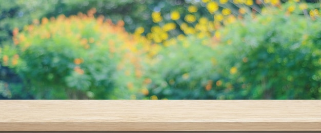 Wooden table for food product display over blur green garden background