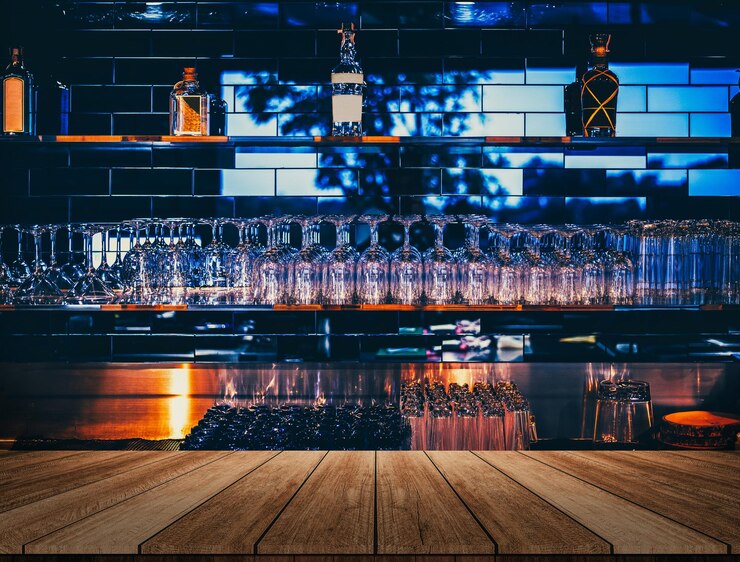 Photo wooden table in front of abstract blurred restaurant lights background of bar