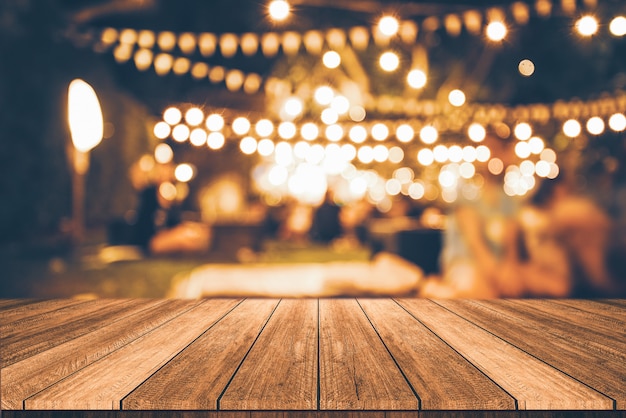 Wooden table in front of abstract blurred restaurant lights background