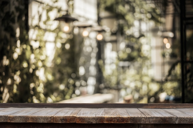 Wooden table in front of indoor garden with table and light bulb decorated 