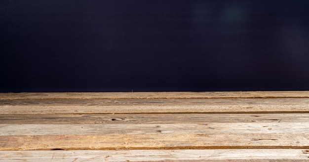 Wooden table in front of rustic wall with empty copy space