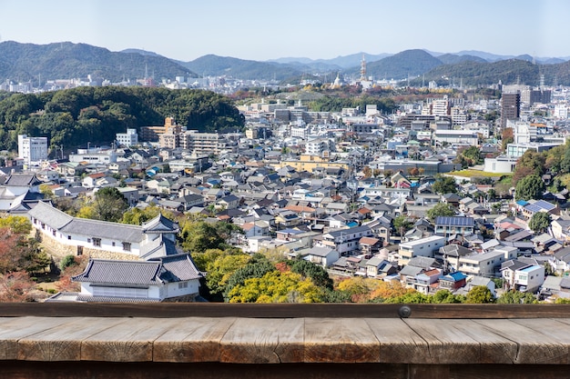 写真 都市の都市のスカイラインの航空写真の背景の前に木製のテーブル