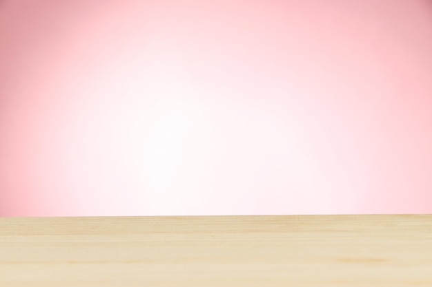 Wooden table on light pink background