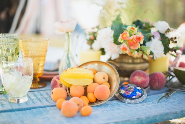 Wooden table made of planks in nature with fruits and flowers