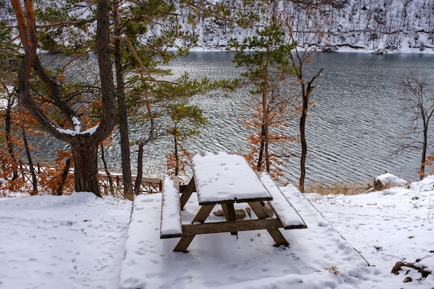 wooden table in the snow by the lake