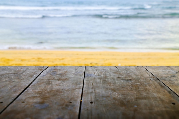 Tavolo in legno su sfondo spiaggia sfocato può essere utilizzato per la visualizzazione