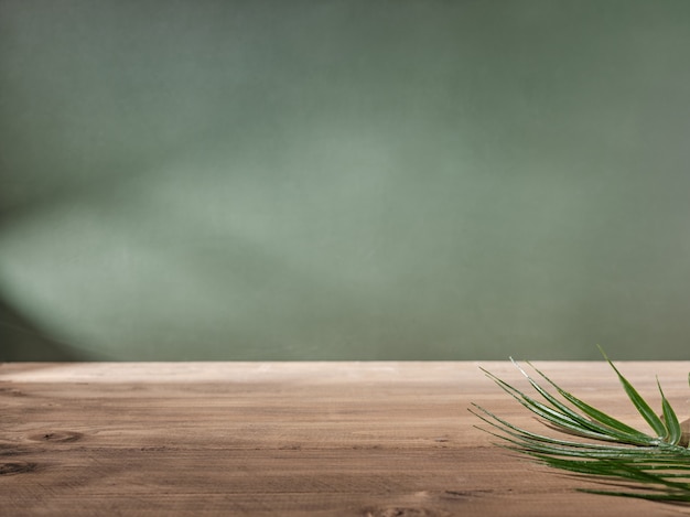 Wooden table top on green wall background