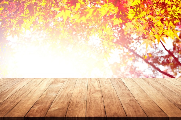 Wooden table top with autumnal leaves