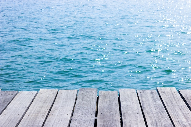 Wooden table top with blue sea background.