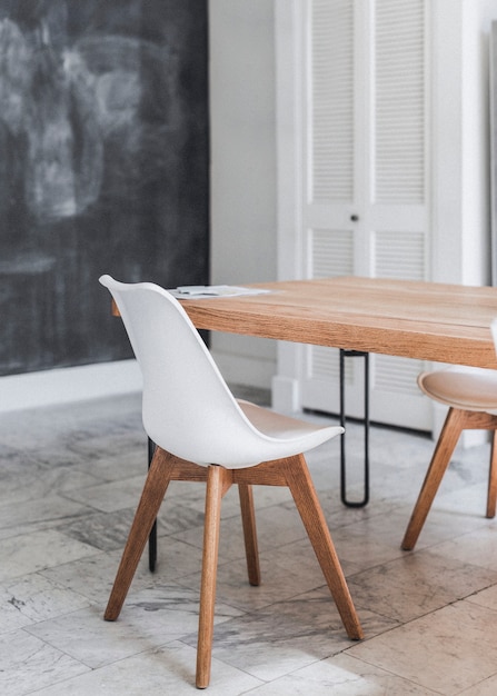 Wooden table and white chair on a marble floor