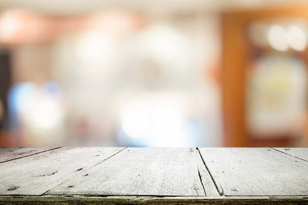 Wooden table with blur background of coffee cafe.