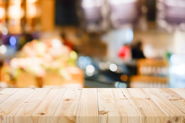 Wooden table with blur background of coffee shop.