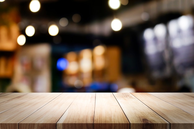 Wooden table with blur background of coffee shop.