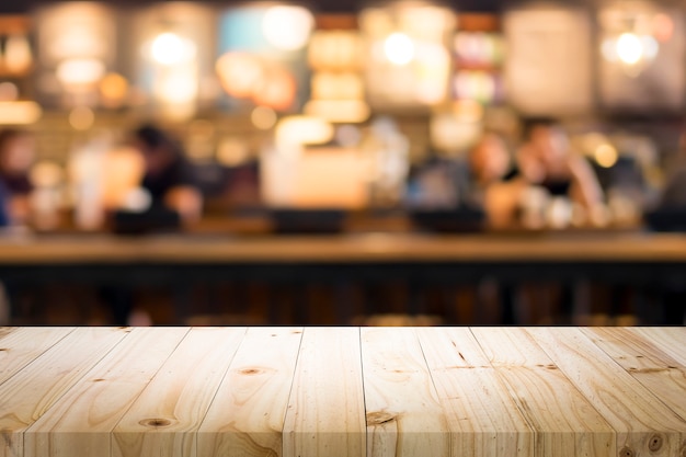 Wooden table with blur background of coffee shop.