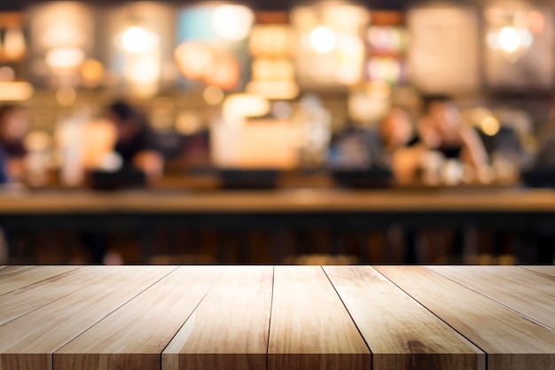 Wooden table with blur background of coffee shop.