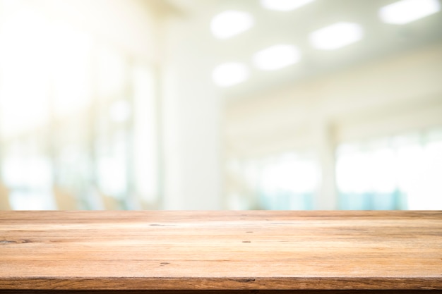 Wooden table with blur background of office room.