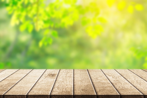 A wooden table with a blurred background of green leaves