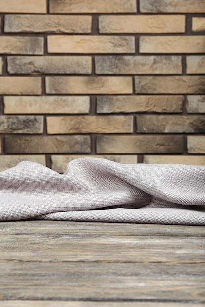 Wooden table with cloth on wall background