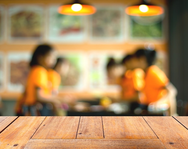 Wooden table with Coffee shop blur background.