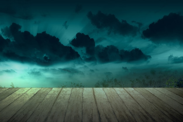 Wooden table with a full moon with dark cloudscapes on the night. Halloween concept