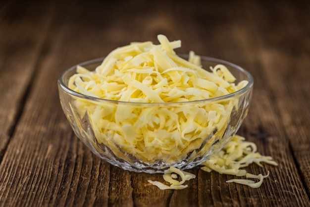 Wooden table with grated Cheese closeup shot