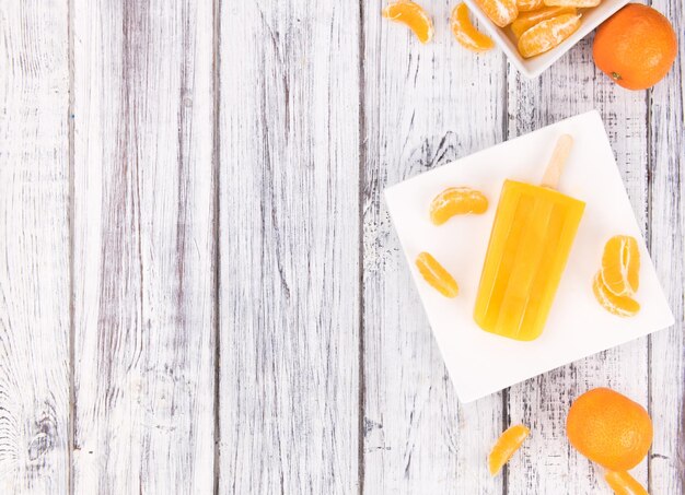 Wooden table with homemade Tangerine Popsicles