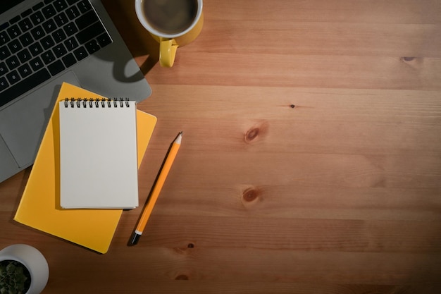 Wooden table with laptop computer notebook and coffee cup Flat lay Top view Copy space