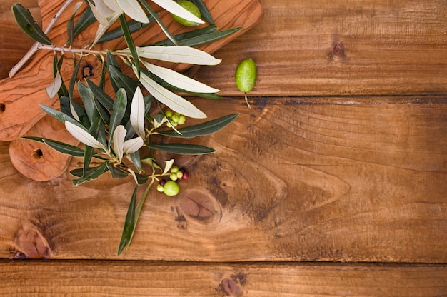 Wooden table with olives and leaves