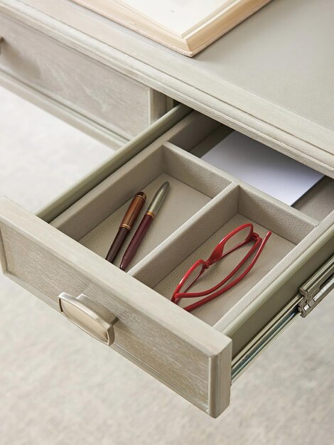 Фото Деревянный стол с открытым ящиком с очками и карандашами, вид сверху