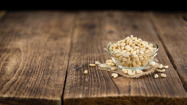 Wooden table with Pine Nuts selective focus