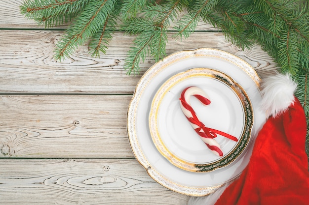 Wooden table with pine tree branches and holiday table setting