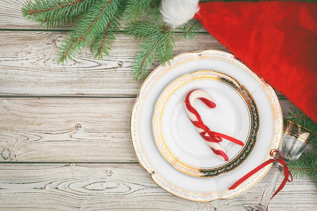 Wooden table with pine tree branches and holiday table setting