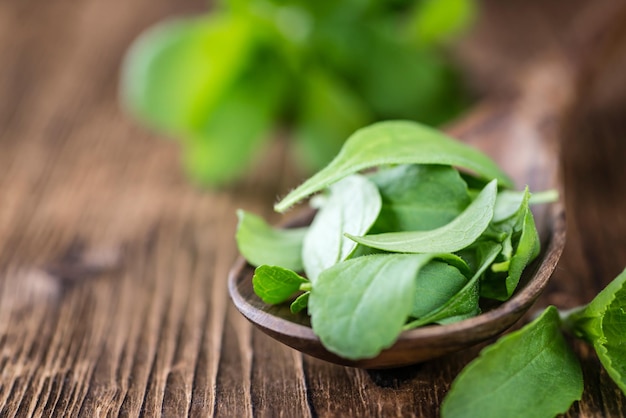 Wooden table with Stevia leaves selective focus