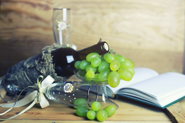 ワインボトルの本とブドウの木製テーブル