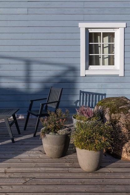 Foto terrazza in legno di una casa di campagna in stile scandinavo con massi coperti di muschio inscritti nel paesaggio