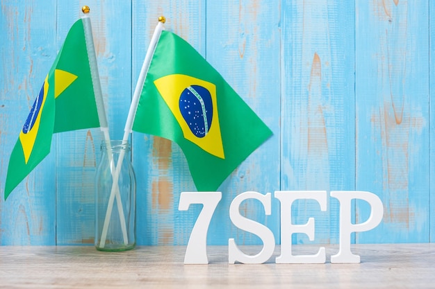 Деревянный текст от 7 августа с миниатюрными бразильскими флагами день независимости бразилии и концепции счастливого празднования