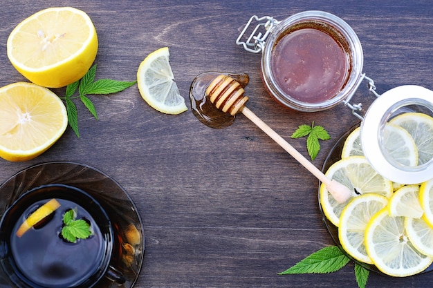 On a wooden texture background a lemon and honey on a spoon