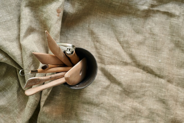 Photo wooden tools for working with clay and ceramics on a linen background in a ceramic glass