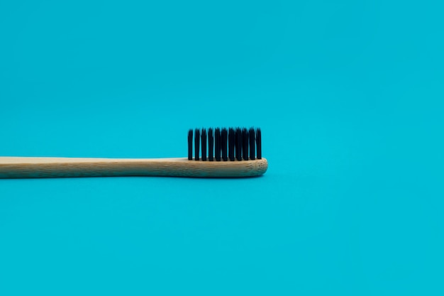 Wooden toothbrush on blue background