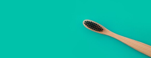 Wooden toothbrush on a green panoramic background