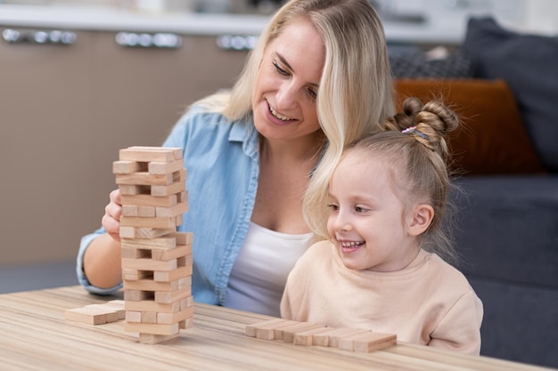 Игра с деревянными башнями Мама и девочка наслаждаются игрой вместе, семьей, играя в настольные игры