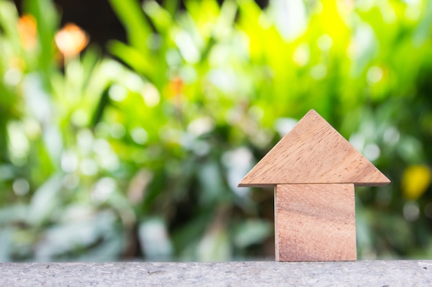 Wooden toy as dream house concept with blurred green blackground