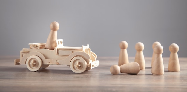 Wooden toy car and human figures. Traffic accident