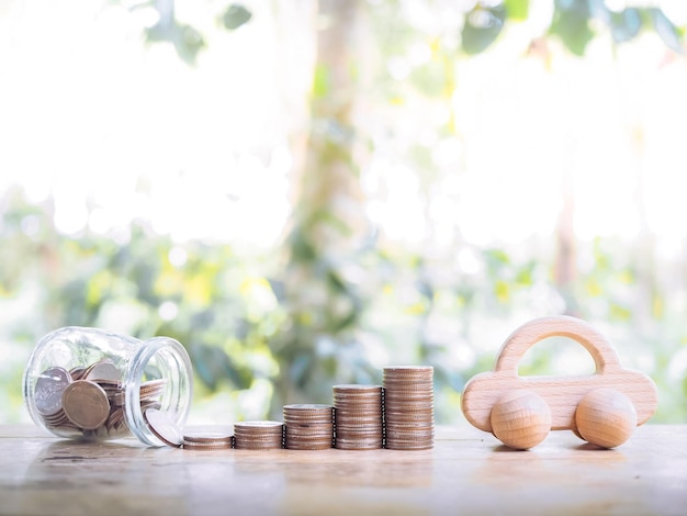 Wooden toy car and stack of coins The concept of saving for car