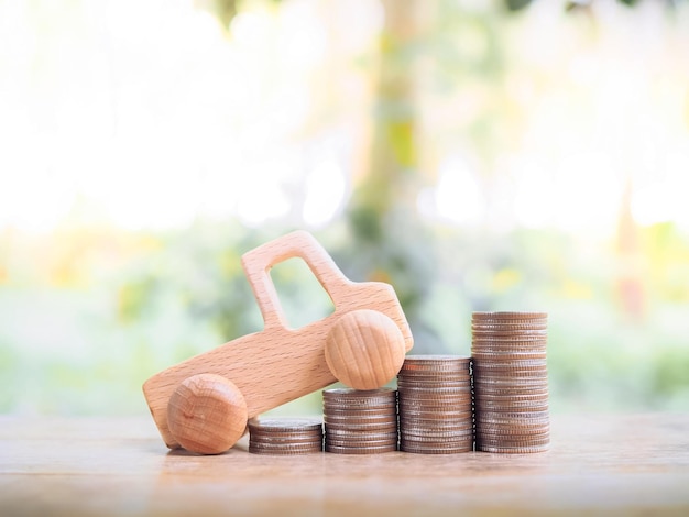 Wooden toy car on stack coins. Saving money for transport and manage for success business concept