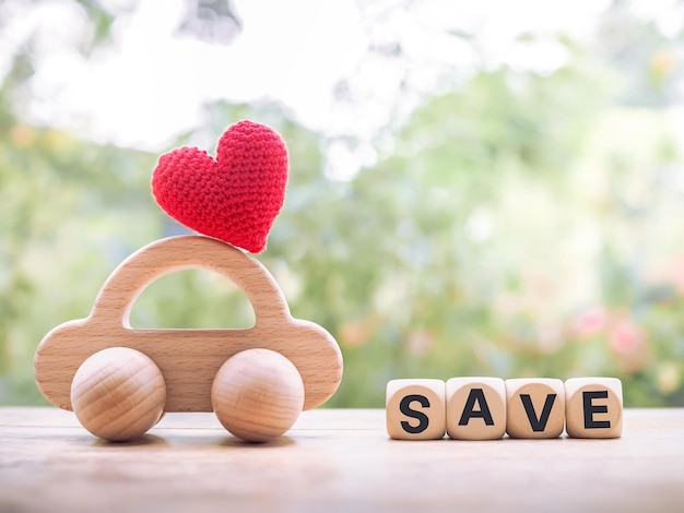 木製のおもちゃの車と「SAVE」という言葉が書かれた木製のブロック 車の節約のコンセプト