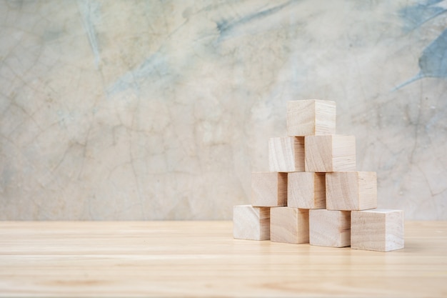 Wooden toy cubes on wooden table ang grey background